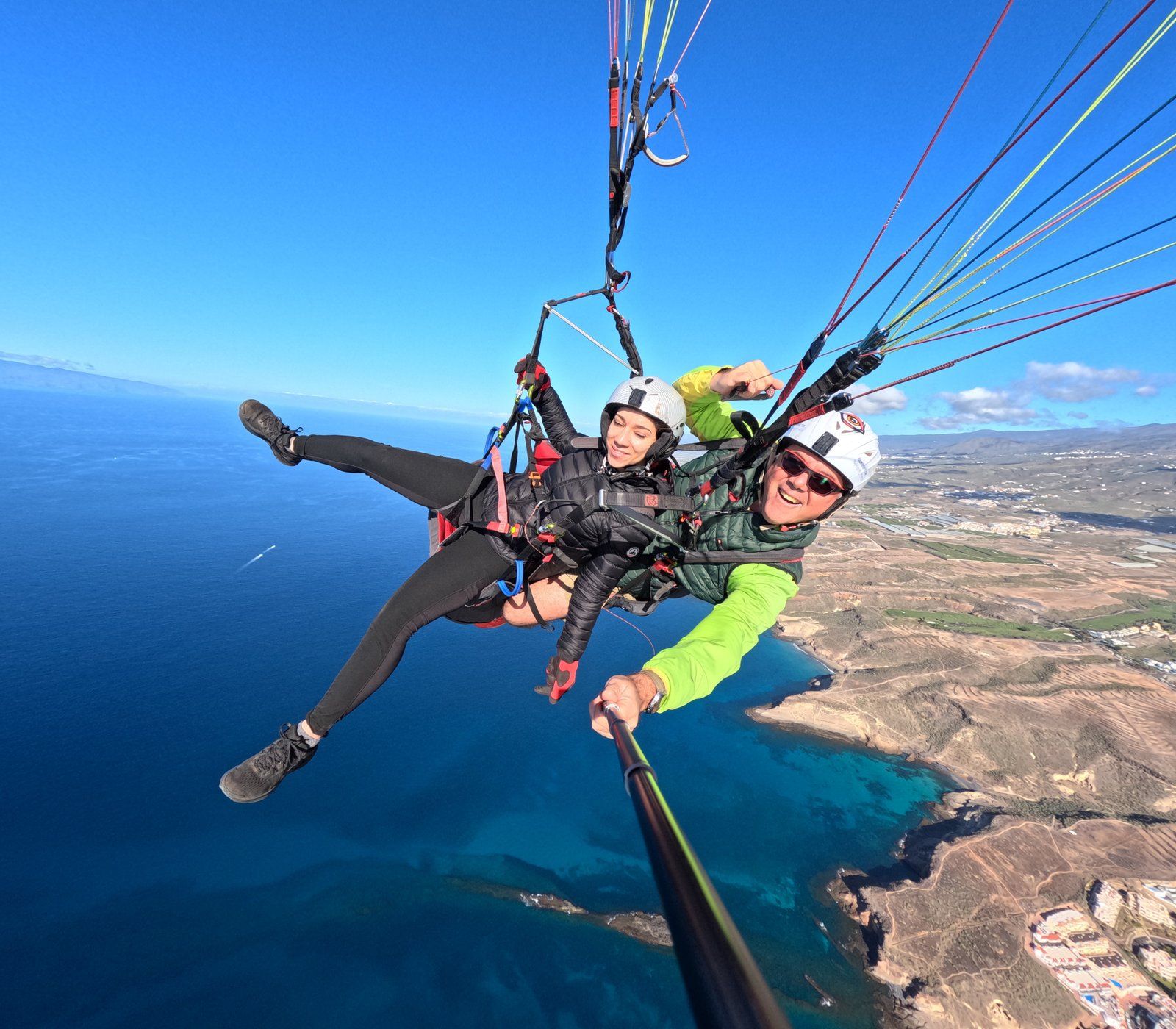 A passenger and a Sky of Tenerife pilot on a tandem paragliding flight above the Adeje coast